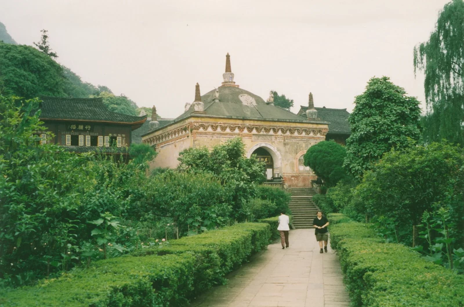 The brick hall of Wannian Temple on Mount Emei surrounded by forested slopes