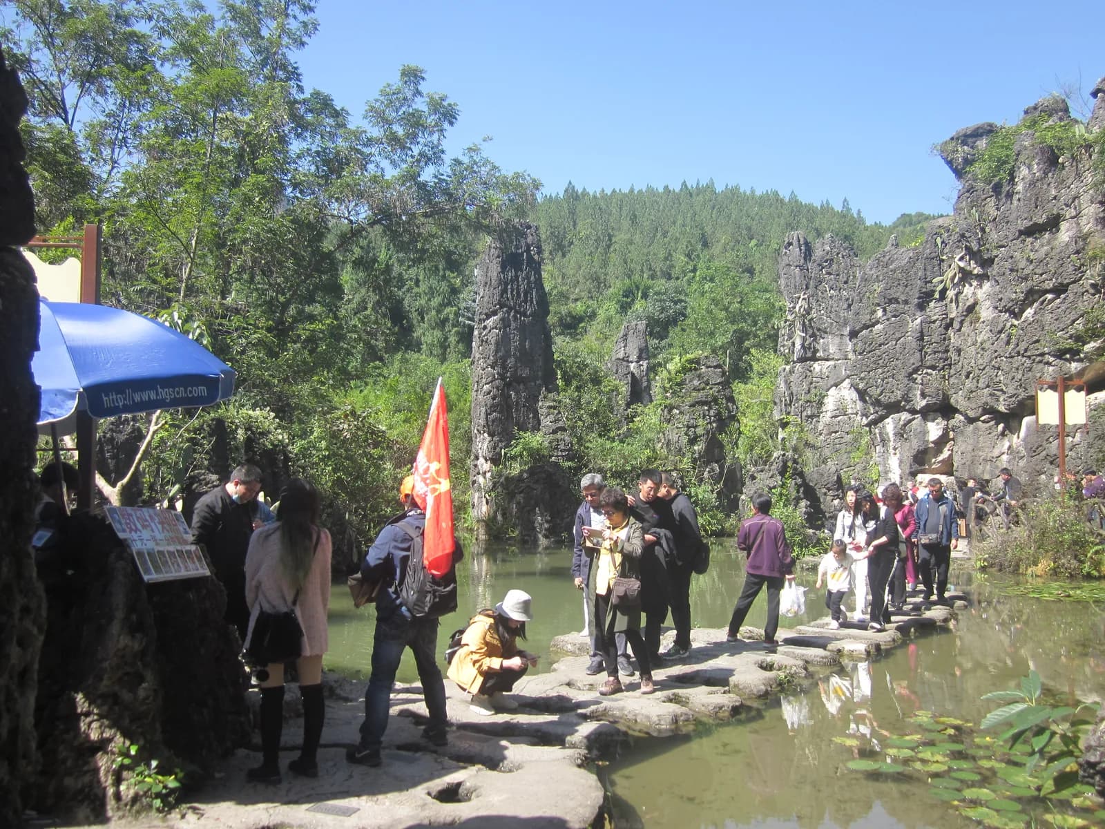 Stepping stones crossing a clear pool between karst rocks at Tianxingqiao scenic area, Huangguoshu