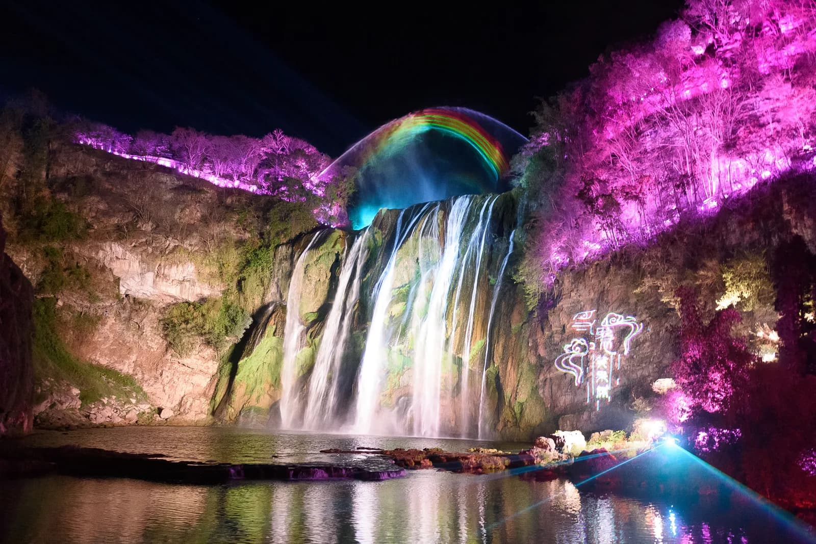 Huangguoshu Waterfall lit with colored floodlights during the evening night tour