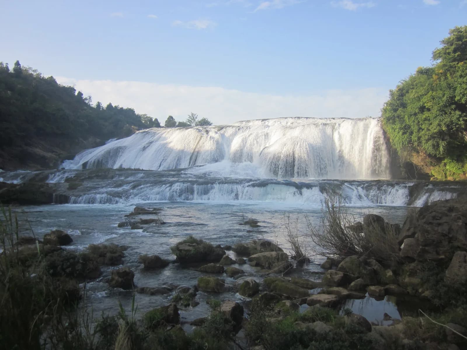 The broad, low curtain of Doupotang Waterfall spanning the full width of the Baishui River at Huangguoshu