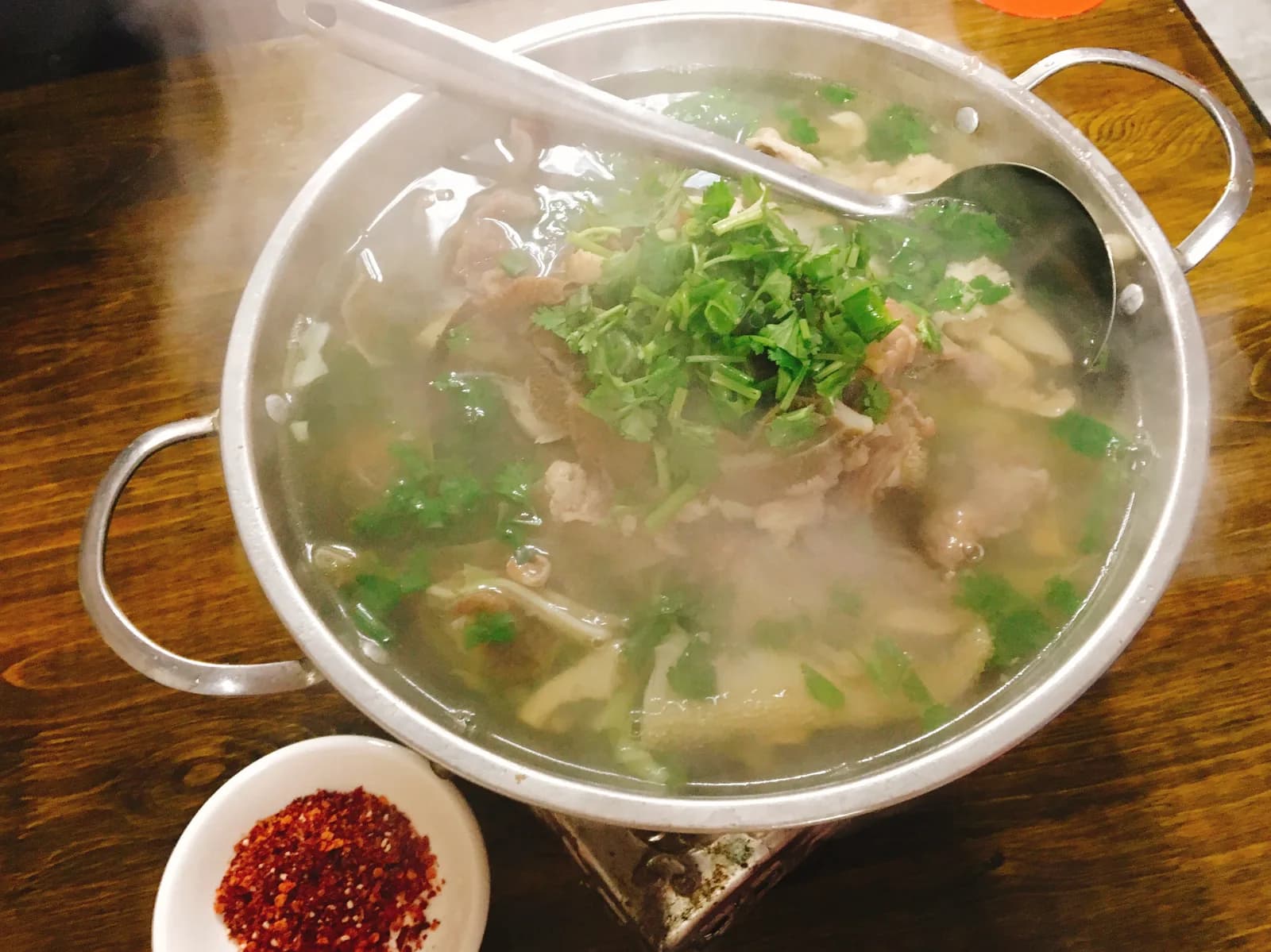 A bowl of qiaojiao beef, sliced beef and offal in clear herbal broth, a specialty of Leshan