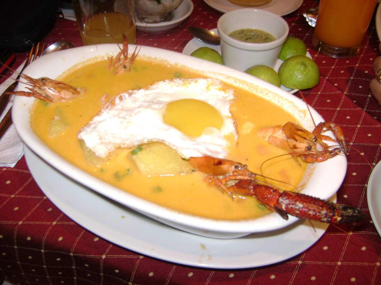 A bowl of chupe de camarones, Peruvian river shrimp chowder with a fried egg, potato and whole shrimp