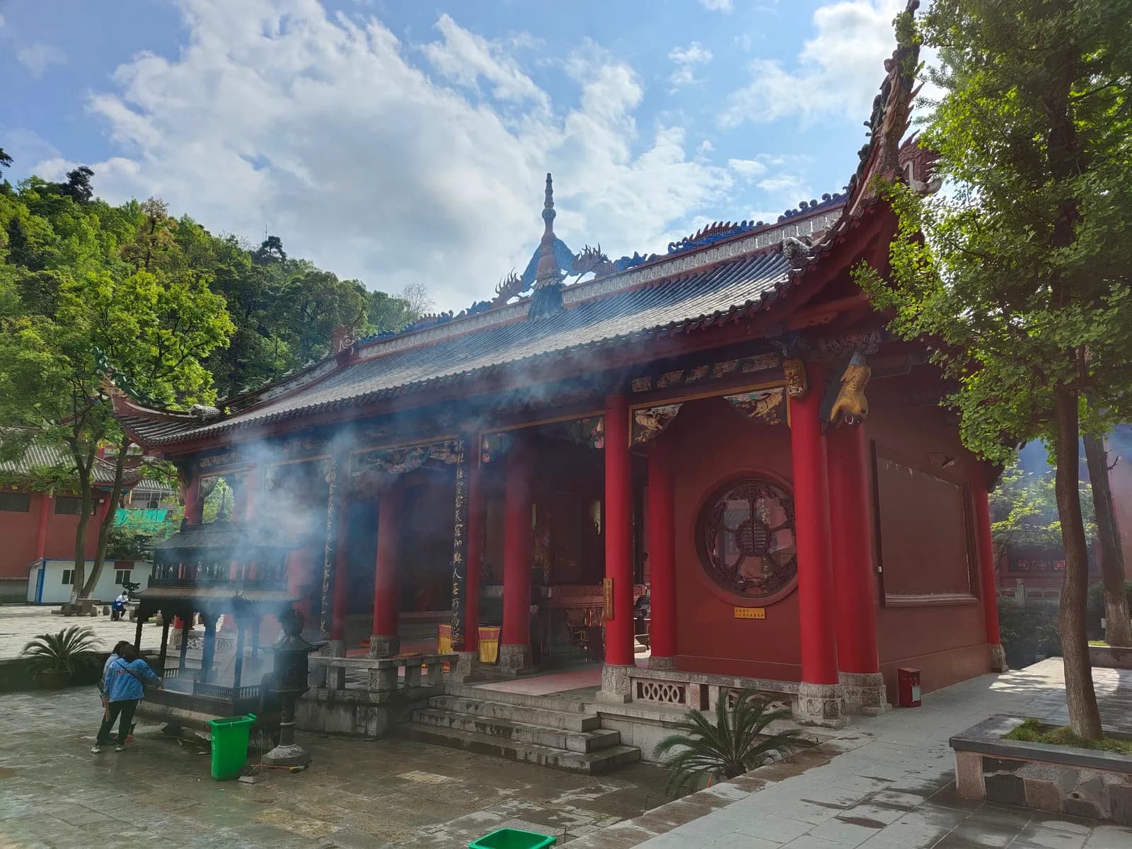 Incense smoke drifting in front of a red-pillared hall of Hongfu Temple on Qianling Mountain in Guiyang