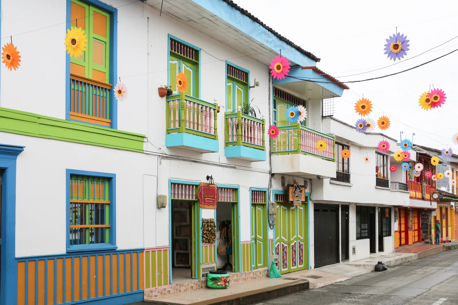 Colorful painted houses with balconies and paper flowers strung over Calle 7 in Filandia, Colombia