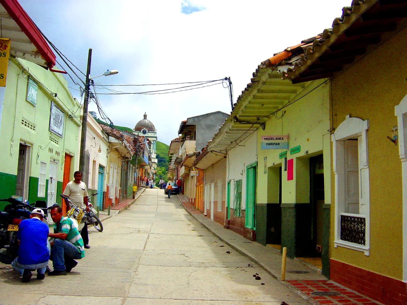 A street of low painted houses in Jardín, Antioquia leading toward the domed church tower