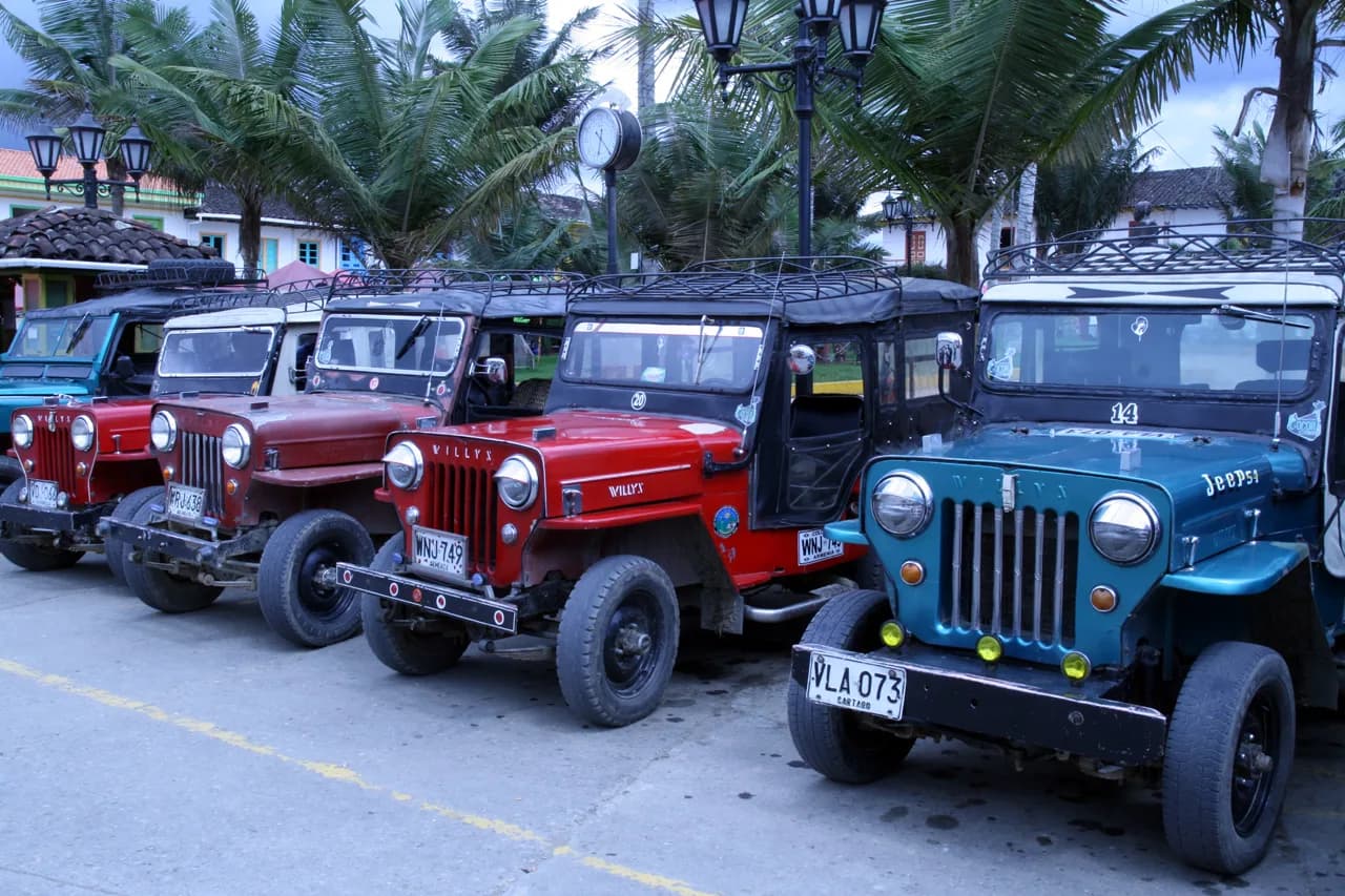 A classic Willys jeep with passengers on the main square of Salento, Colombia