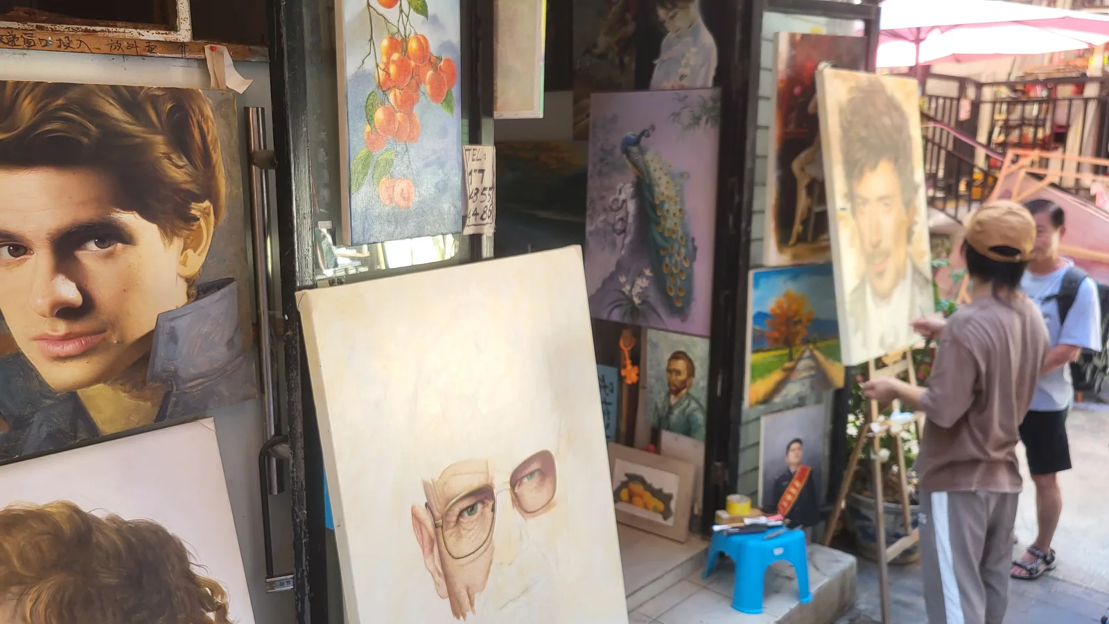 Shopfronts hung with rows of oil paintings in a lane of Dafen Oil Painting Village, Shenzhen