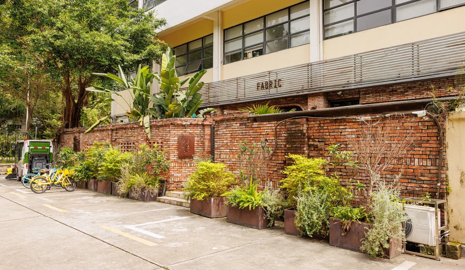 Renovated brick factory buildings with trees and cafes at OCT-LOFT creative park in Nanshan, Shenzhen