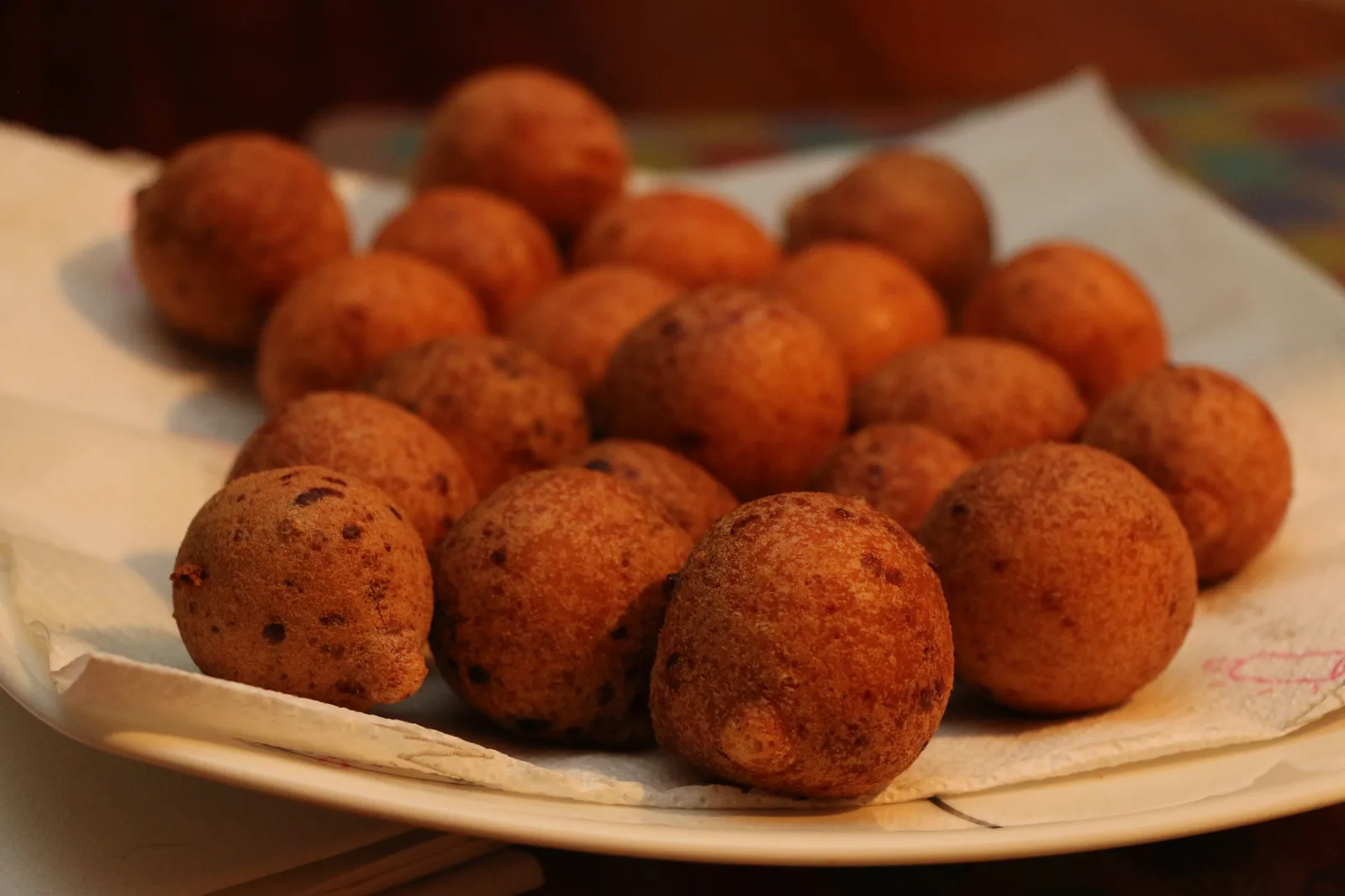 Golden Colombian buñuelos, round fried cheese-dough balls, piled in a bowl