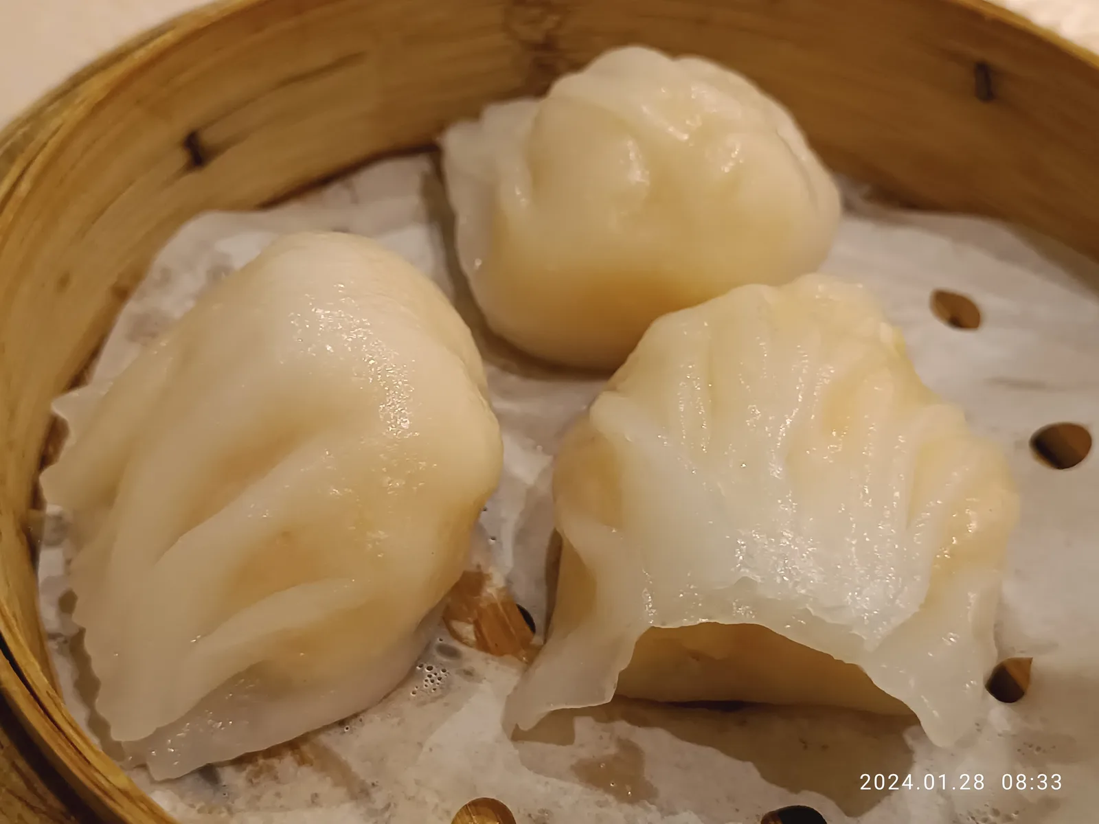 A steamer basket of har gow, translucent shrimp dumplings pleated by hand, at a Cantonese dim sum restaurant