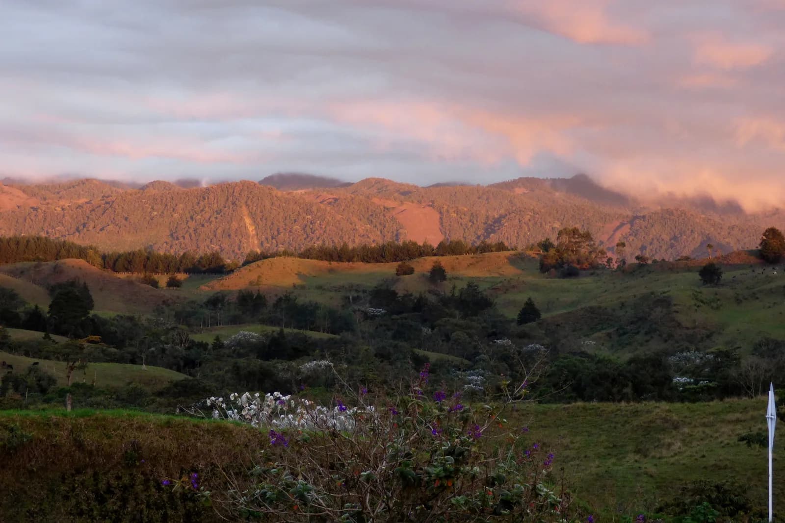 Orange and purple sunset over the rooftops and green hills of Filandia, Colombia
