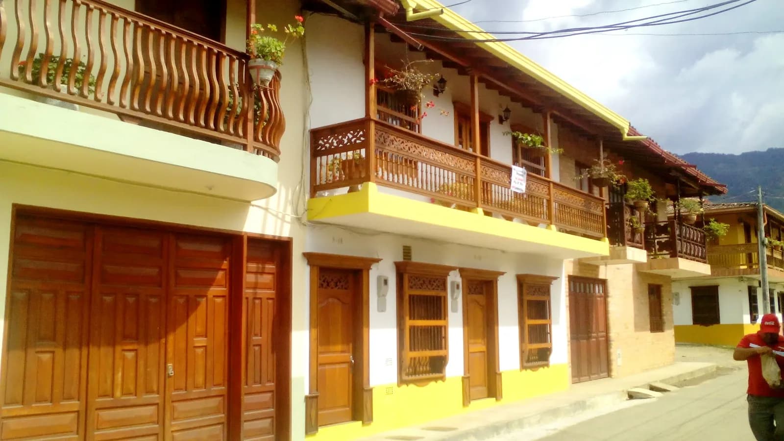 Brightly painted house facades in yellow, red and blue along a street in Jardín, Antioquia, Colombia