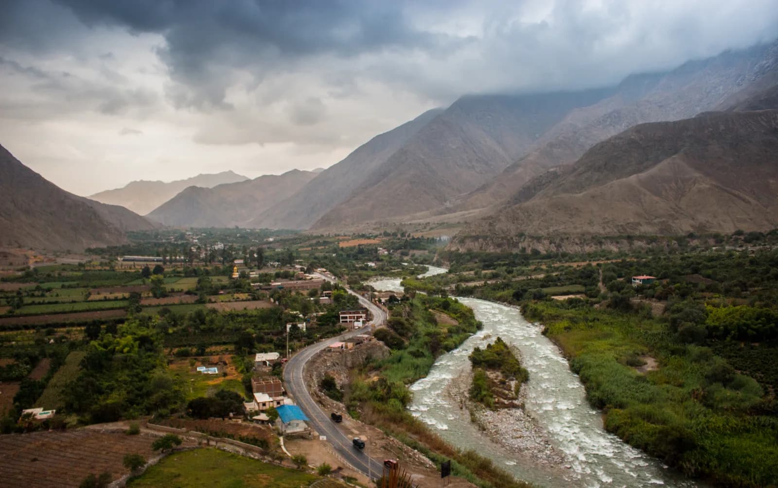 Aerial view of the Lunahuaná valley with the Río Cañete, the valley road and lodges strung along the riverbanks between dry Andean hills