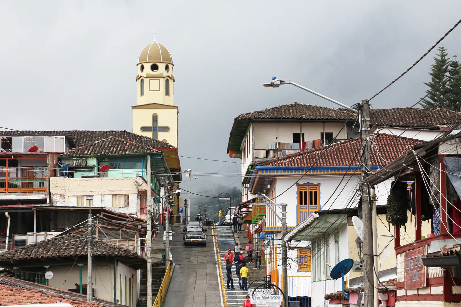 Colorful colonial buildings and painted doorways lining a street in the center of Salento, Colombia