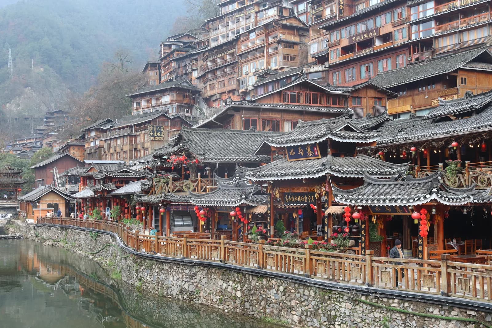Wooden guesthouses on the mid-hill lanes of Xijiang Miao Village looking down toward the riverside